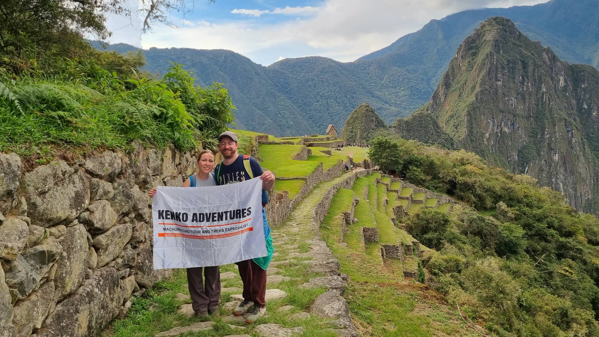 A couple embracing and smiling with the ancient ruins of Machu Picchu and the lush green Andes mountains in the background. A couple embracing and smiling with the ancient ruins of Machu Picchu and the lush green Andes mountains in the background.