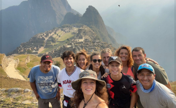 Group of travelers at Machu Picchu overlooking ancient ruins