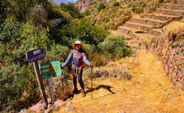 Hikers making their way up a steep stone staircase carved into the mountainside.