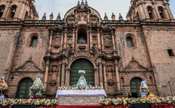 Images of saints and virgins in front of Cusco Cathedral during the Corpus Christi festival, surrounded by flowers and devotees - Kenko Adventure