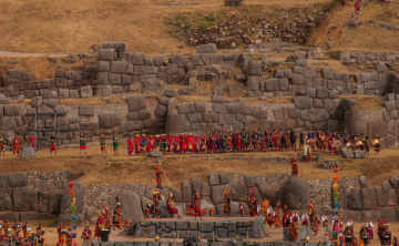 Inti Raymi ceremony at Sacsayhuamán with participants in traditional costumes and ancient stone ruins, Kenko Adventures
