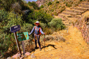 Hikers making their way up a steep stone staircase carved into the mountainside.